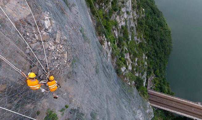 People work on cliff to ensure railway safety in C China's Henan