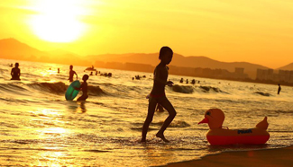 People cool off at beach in Sanya City on hot summer