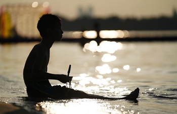 People enjoy themselves near Songhuajiang river in Harbin